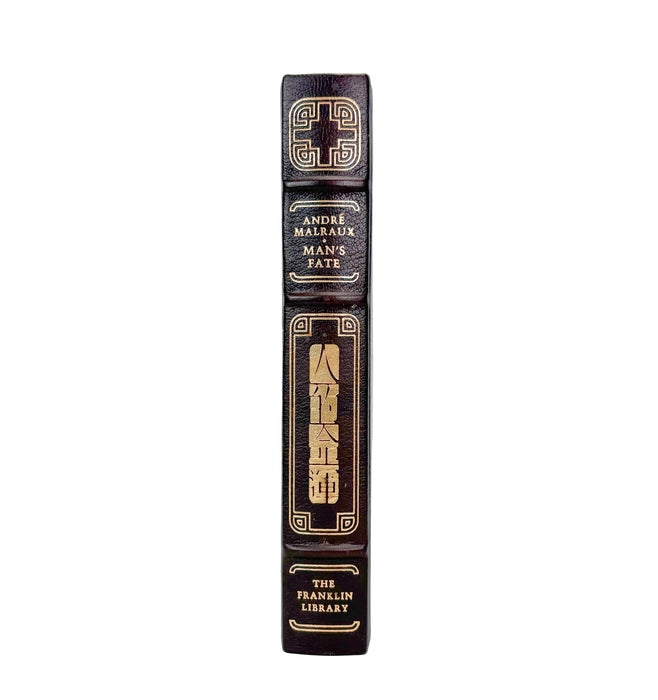 A close-up vertical shot of a book spine, showing the title 'The Franklin Library' by Andre Malleaux, with gold decorative lettering and borders on a dark brown leather-like background, set against a plain white background.