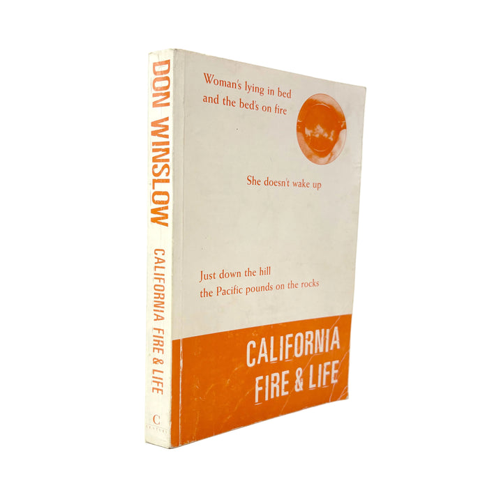 A vintage paperback book of Don Winslow's 'California Fire & Life' by Don Winslow, standing upright on a white background. The book features a cream-colored cover with orange text and graphics, and a solid orange band at the bottom.