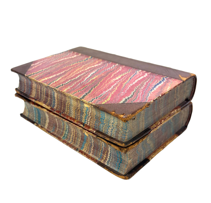 Stack of vintage books with colorful cloth bindings on a white background