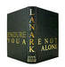 A hardcover book shown at a three-quarter angle on a white background, featuring a black cover with gold foil lettering. The spine displays the title 'LANARK' vertically, and the front cover shows 'ENDURE YOU ARE NOT ALONE'.