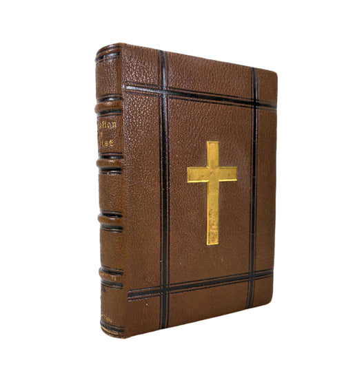 Brown leather-bound book with a gold cross on a white background