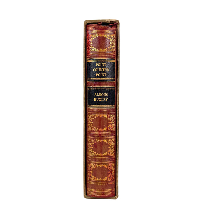 A vintage hardcover book standing upright, showing its spine with gold decorative bands and black title labels reading 'POINT COUNTER POINT' and 'ALDUS HUXLEY'.