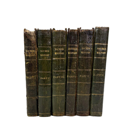 A set of six antique leather-bound books standing upright against a plain white background. The spines are dark brown and greenish-black with gold lettering reading 'SACRED HISTORY' and section titles like 'PART I', 'PART II', and 'PART III'.