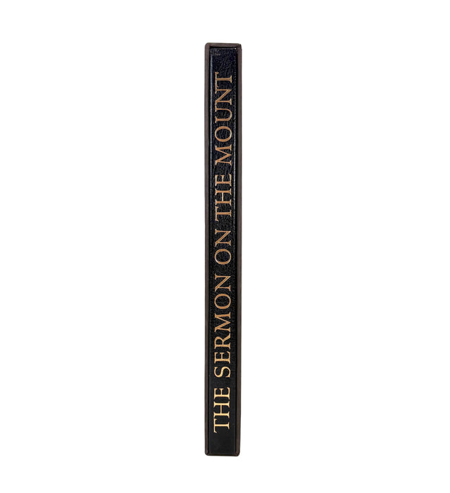 A single book standing upright on its spine against a plain white background. The spine is dark brown with gold lettering that reads 'THE SERMON ON THE MOUNT'.