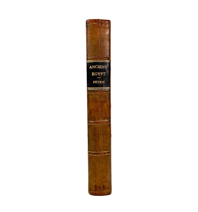 Vintage book titled 'Ancient Egypt' by Petrie with a brown leather cover on a white background