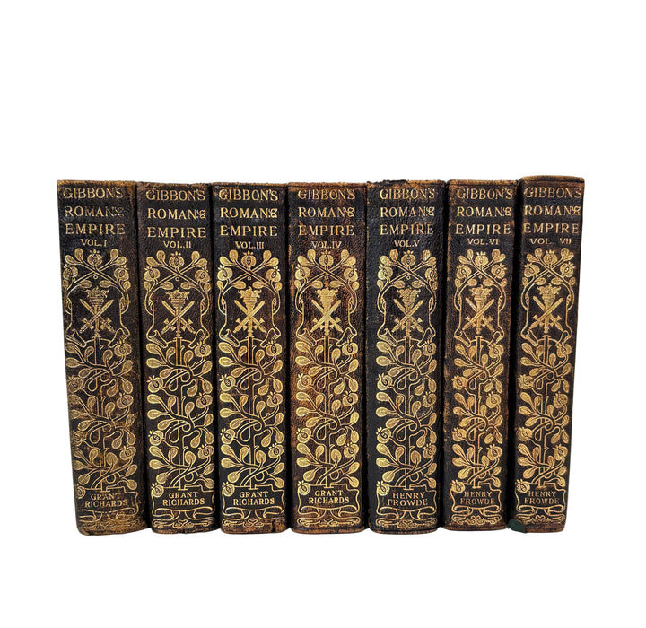 A set of seven hardcover books from 'Gibbons' Roman Empire Library' arranged in a row against a plain white background. The book spines are dark brown leather with ornate gold foil embossed patterns and lettering.