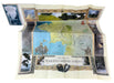 The map of Tolkien's Middle-earth playmat, fully unfolded to show its detailed design, accompanied by the map box and two small dragon figurines, set against a plain light background.