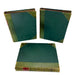 Three vintage hardcover books with dark green covers and gold-ochre tooling on the corners and spine, arranged on a white background with two standing upright and one lying flat.