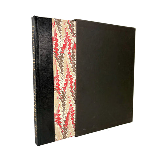 A vintage hardcover book or album standing upright, featuring a black textured cover with a decorative patterned spine panel in beige, red, and brown.