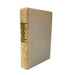A vintage hardcover book titled 'The Seven Who Fled' by Friedrich Paulosch, standing upright on a white background. The book features a light grayish-blue cloth cover with significant yellowing and age staining, and a tan-beige spine with black text.