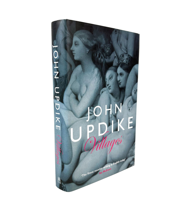A hardcover book titled 'Villages' by John Updike, standing upright at a slight angle on a white background. The cover features a dark, moody classical painting of several women, with the title 'Villages' in pink script and the author's name 'JOHN UPDIKE' in large white text.